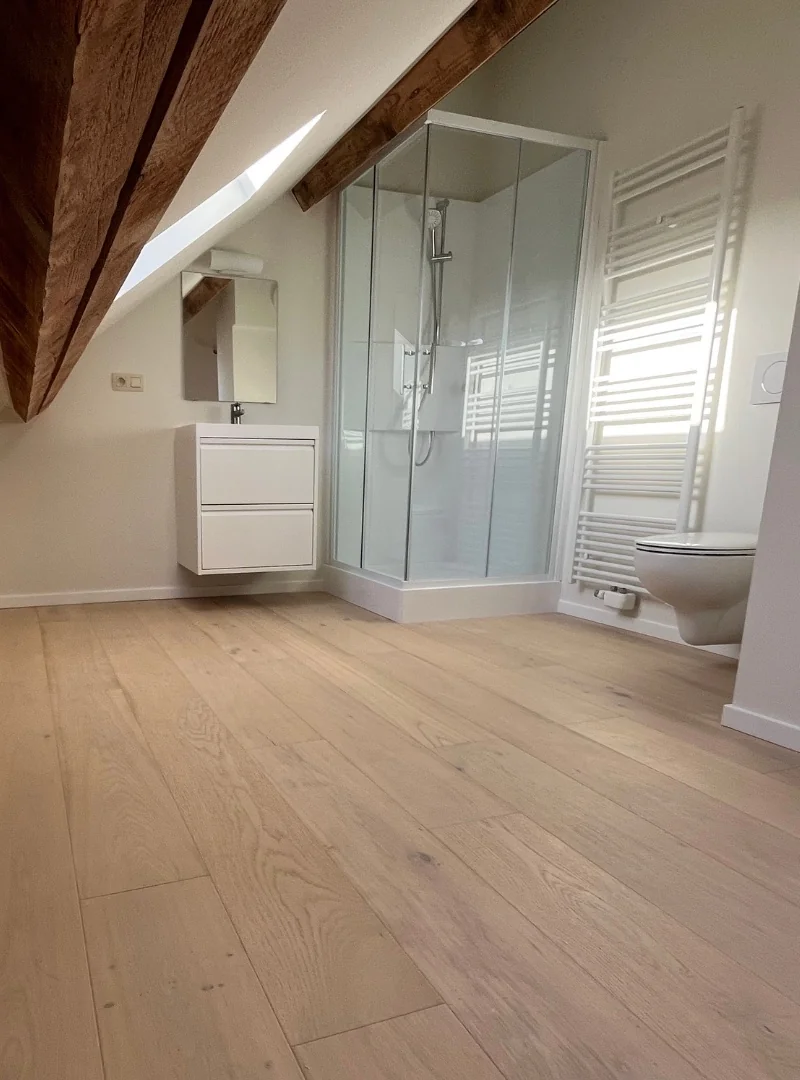 Renovatie van een zolderbadkamer met behouden balken, project van Terravec in Vlaams-Brabant