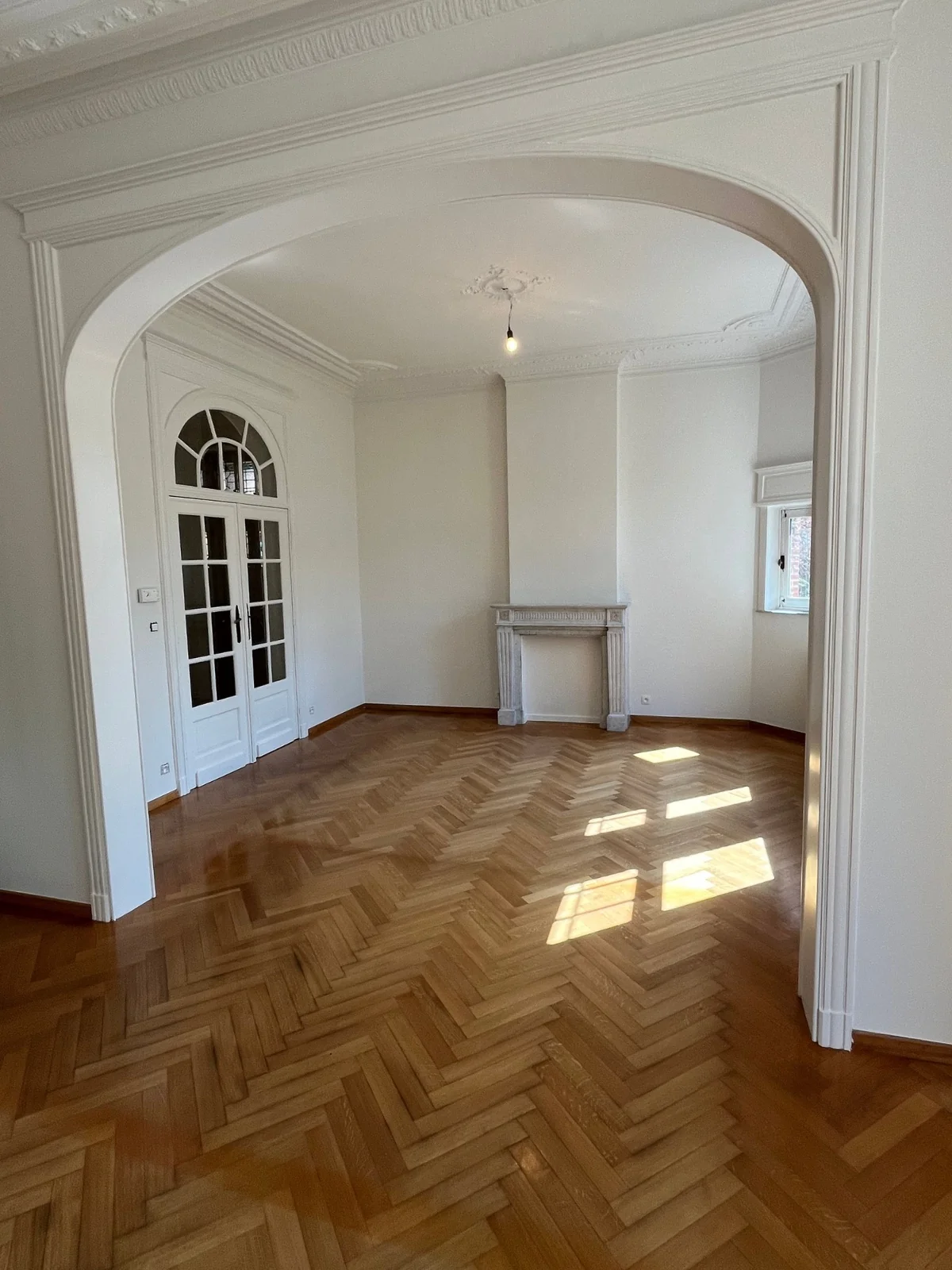 Restauratie van een klassiek herenhuis: gerestaureerde arcade, visgraatvloer en stucwerk