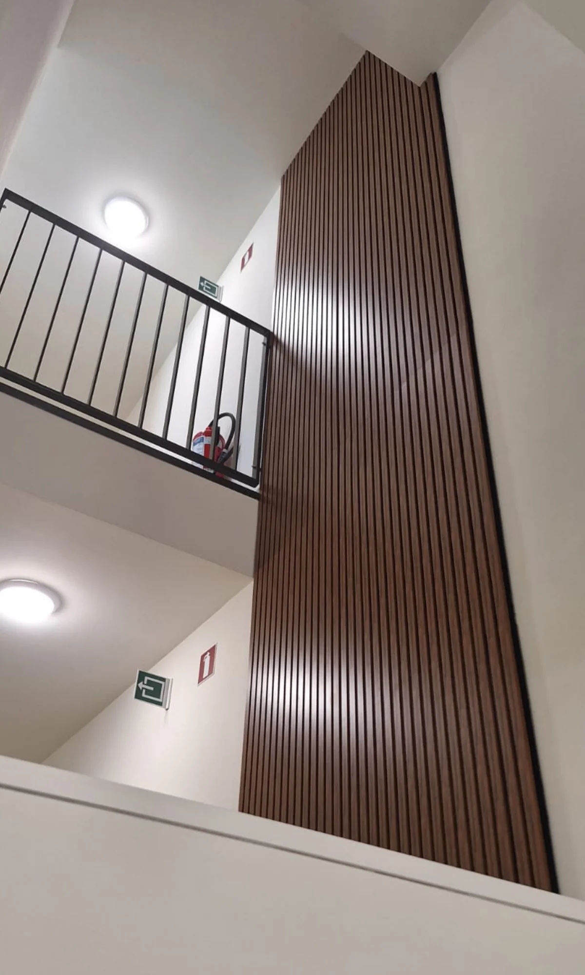 Vernieuwd trappenhuis met houten lamellenwand als akoestisch en visueel accent